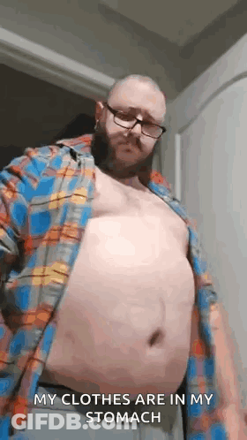 Man With Glasses And Beard Taking Off Shirt GIF