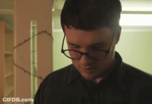 Man With Glasses And Black Shirt Looking Down GIF