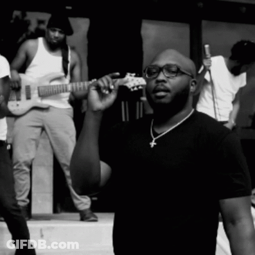 Man With Glasses And Cross Necklace Holding Guitar GIF
