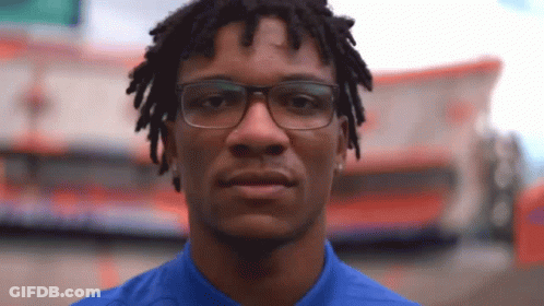 Man With Glasses And Dreadlocks Looking At Camera GIF