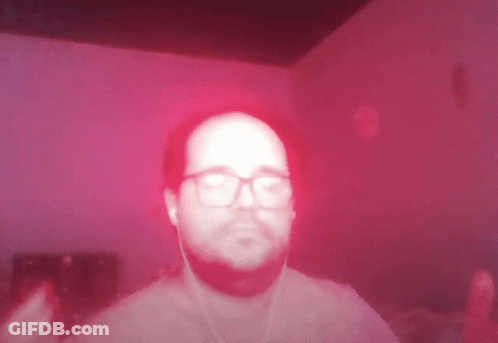 Man With Glasses And Ear Buds On Red Background GIF