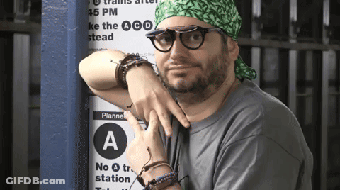 Man With Glasses And Green Headband Leaning Against Planne A Sign GIF