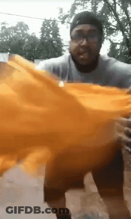 Man With Glasses And Hat Holding Orange Cloth GIF