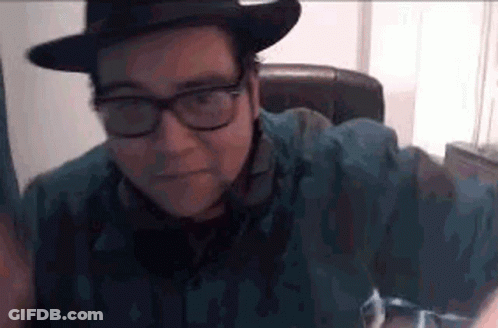Man With Glasses And Hat Sitting In Chair GIF
