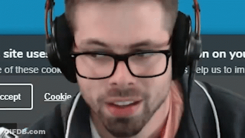 Man With Glasses And Headphones Smiling At Cookie Screen GIF