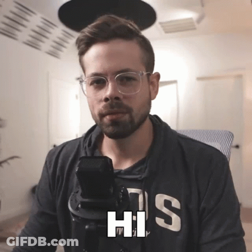 Man With Glasses And Hoodie His Talking Into Microphone GIF