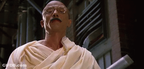 Man With Glasses And Mustache In White Robe Holding Stick GIF