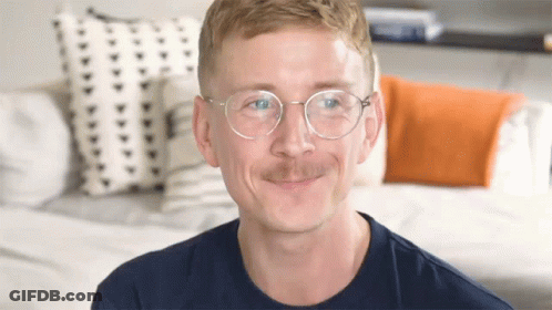 Man With Glasses And Mustache Smiling On Couch GIF