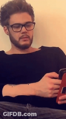 Man With Glasses And Nose Ring Looking At Phone GIF