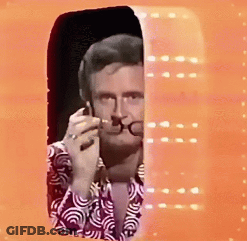 Man With Glasses And Purple Shirt Smoking By Window GIF