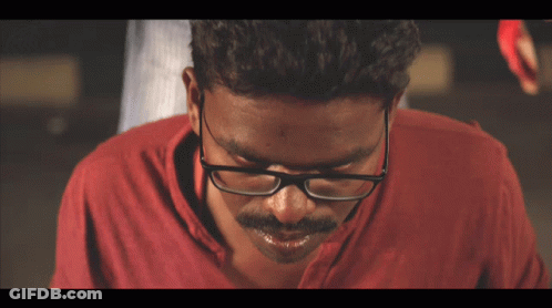 Man With Glasses And Red Shirt Looking Down GIF
