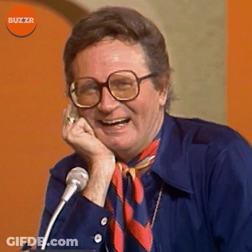 Man With Glasses And Scarf Smiling At Microphone Buzzr GIF