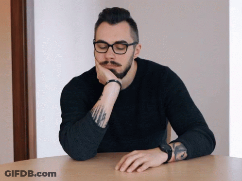 Man With Glasses And Tattoo Resting Hand On Chin GIF