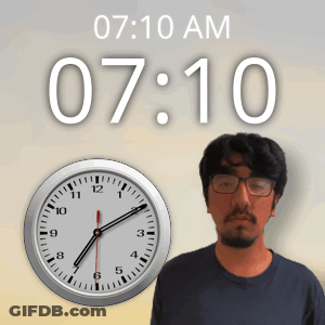 Man With Glasses By Clock Showing 7:10 AM GIF