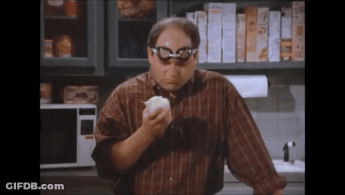 Man With Glasses Eating Bread In Kitchen GIF