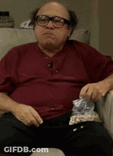 Man With Glasses Eating Popcorn On Couch GIF