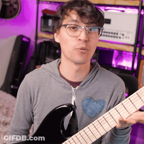 Man With Glasses Holding Guitar Making Funny Face GIF