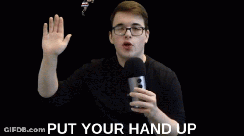 Man With Glasses Holding Microphone Saying Put Your Hand Up GIF