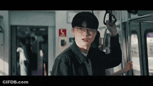 Man With Glasses Holding Railing On Train GIF