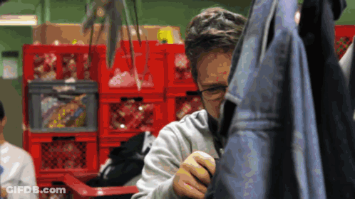 Man With Glasses In Front Of Red Crates GIF