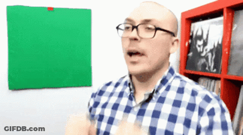 Man With Glasses In Plaid Shirt In Front Of Green Board GIF