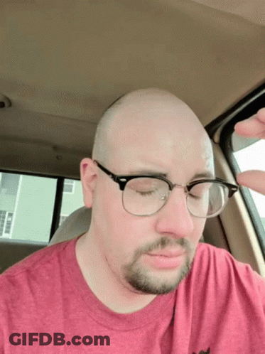Man With Glasses In Red Shirt Eyes Closed In Car GIF
