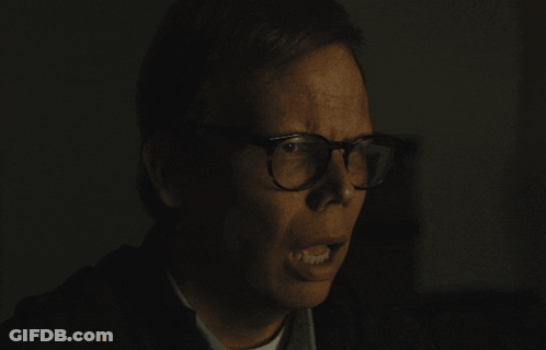 Man With Glasses Making Funny Face In Dark Room GIF
