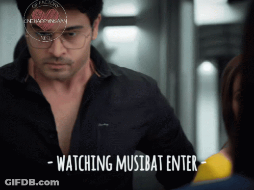 Man With Glasses Next To Woman Watching Musibat Enter GIF
