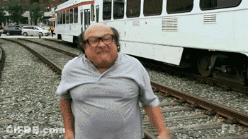Man With Glasses On Train Tracks Near Bus GIF
