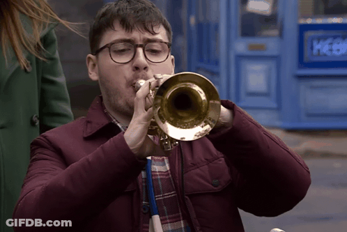 Man With Glasses Playing Trumpet At Blue Door Picker GIF