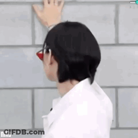 Man With Glasses Red Nose Hand On Brick Wall GIF