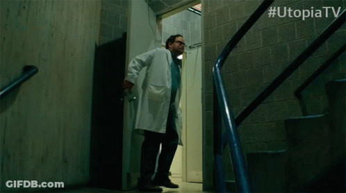 Man With Glasses Saying Wait In Front Of Utopia TV Logo GIF