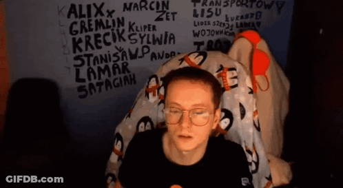 Man With Glasses Sitting In Front Of Graffiti Wall GIF