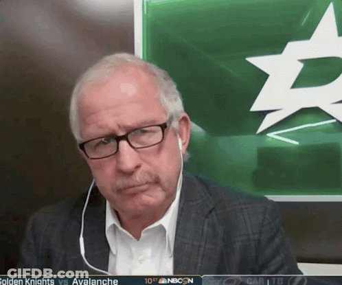 Man With Glasses Sitting In Front Of Green Board With Star GIF