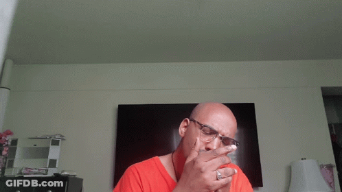 Man With Glasses Smoking Cigarette In Front Of TV GIF