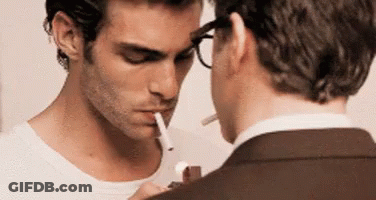 Man With Glasses Smoking Cigarette Next To Man In Suit GIF