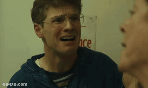 Man With Glasses Talking To Another Man In Front Of Sign Saying Ance GIF