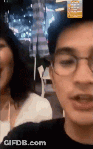 Man With Glasses Talking To Woman In Blurry Photo GIF