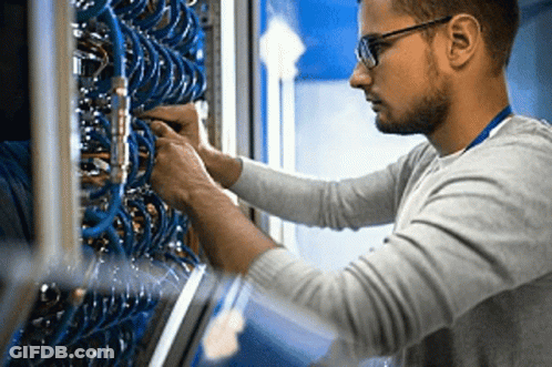 Man With Glasses Working On Server In Data Center GIF