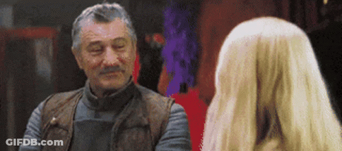 Man With Gray Hair And Mustache Talking To Blonde Woman GIF