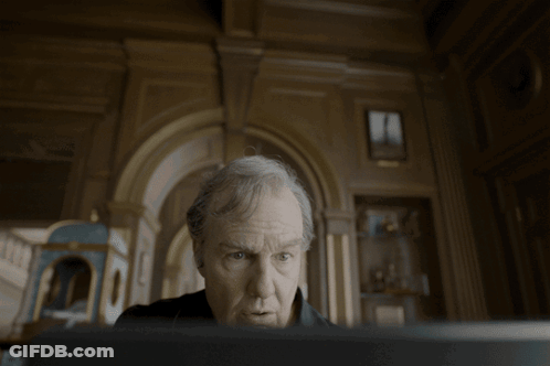 Man With Gray Hair Looking At Screen In Dark Room GIF