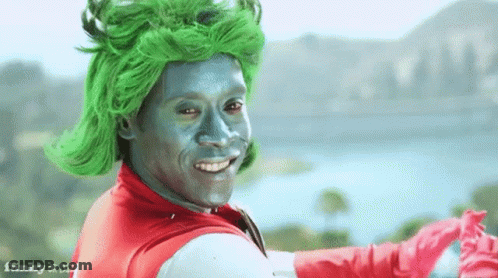 Man With Green Hair And Silver Face Paint In Superhero Costume GIF