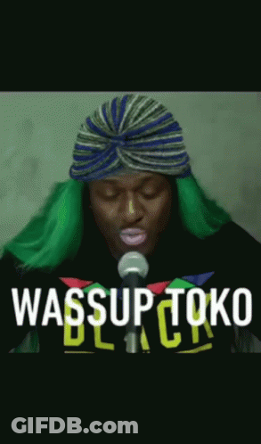 Man With Green Hair Singing Into Microphone Wearing Turban GIF