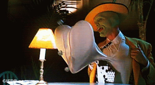 Man With Green Mask Sitting Next To Lamp GIF