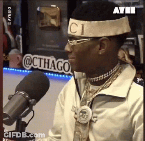 Man With Gucci Headband Sitting At Microphone GIF