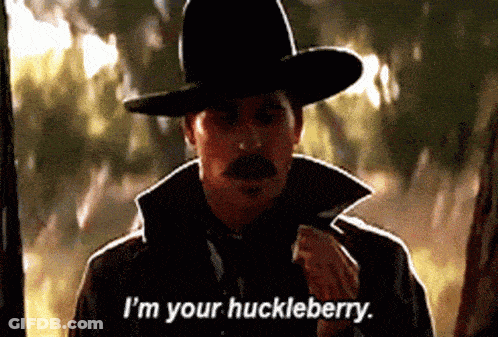Man With Gun And American Flag Saying I'm Your Huckleberry GIF