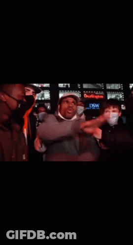 Man With Hat And Headphones Surrounded By People GIF