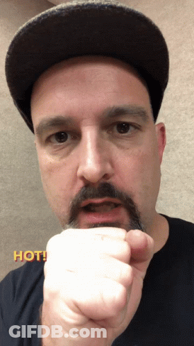 Man With Hat And Mustache Holding Fist Up Saying Hot GIF