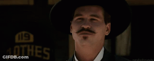 Man With Hat And Mustache Waving In Front Of Hes Sign GIF