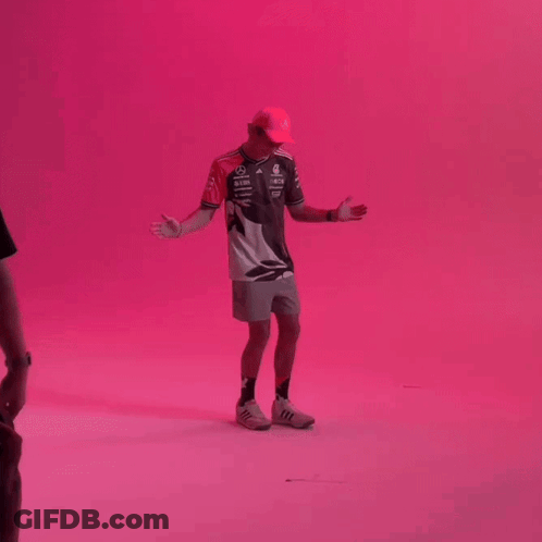 Man With Hat Arms Outstretched Pink Wall GIF